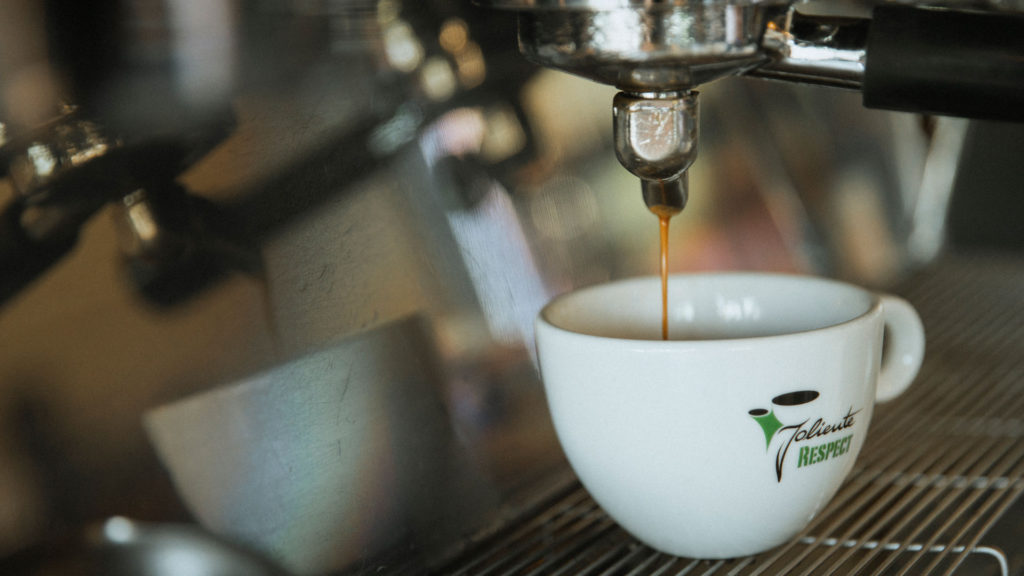 Nahaufnahme - Kaffee läuft aus der Kaffeemaschine in die Tasse